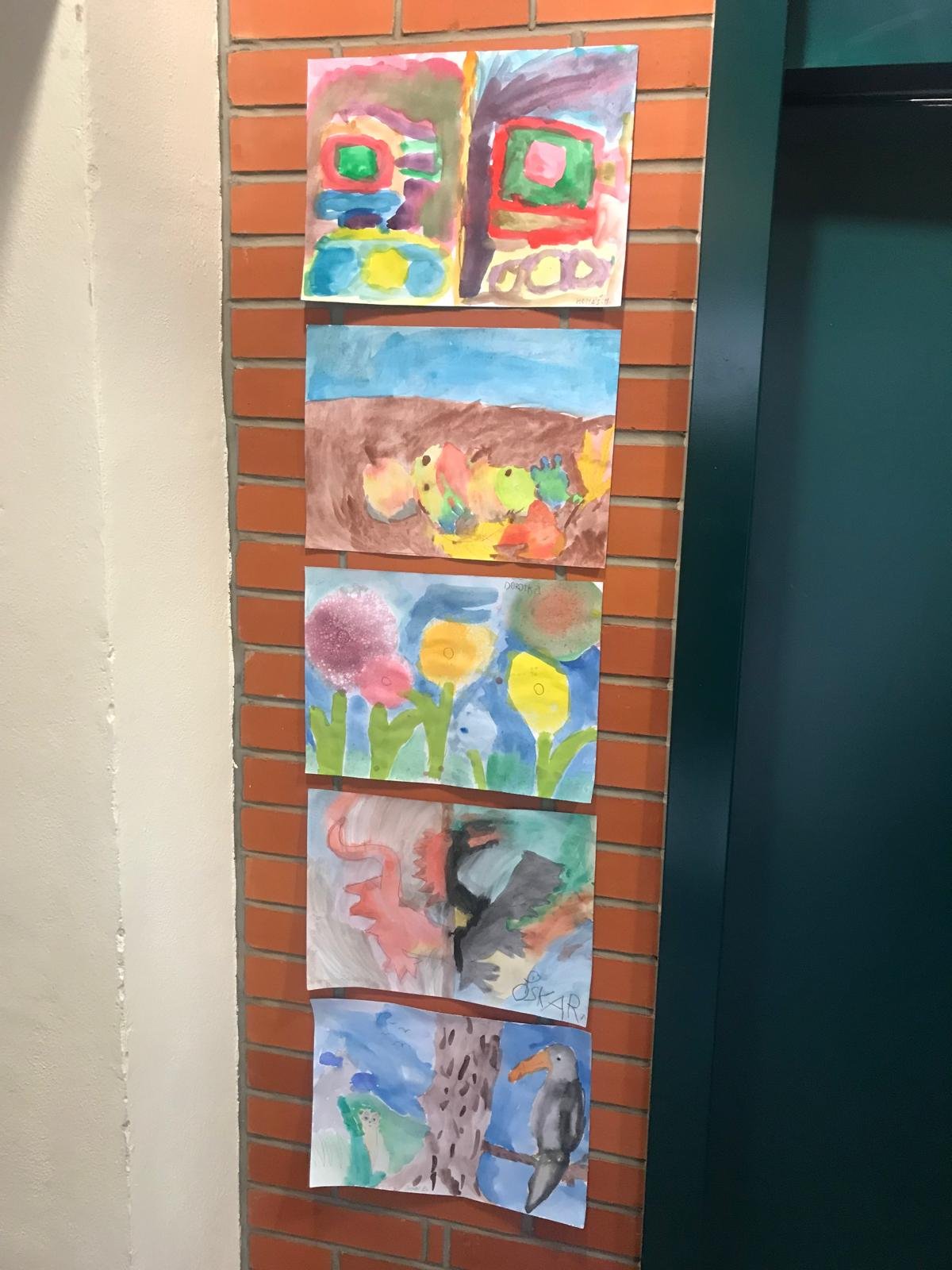 Dětské práce vystavené na zdi ateliéru